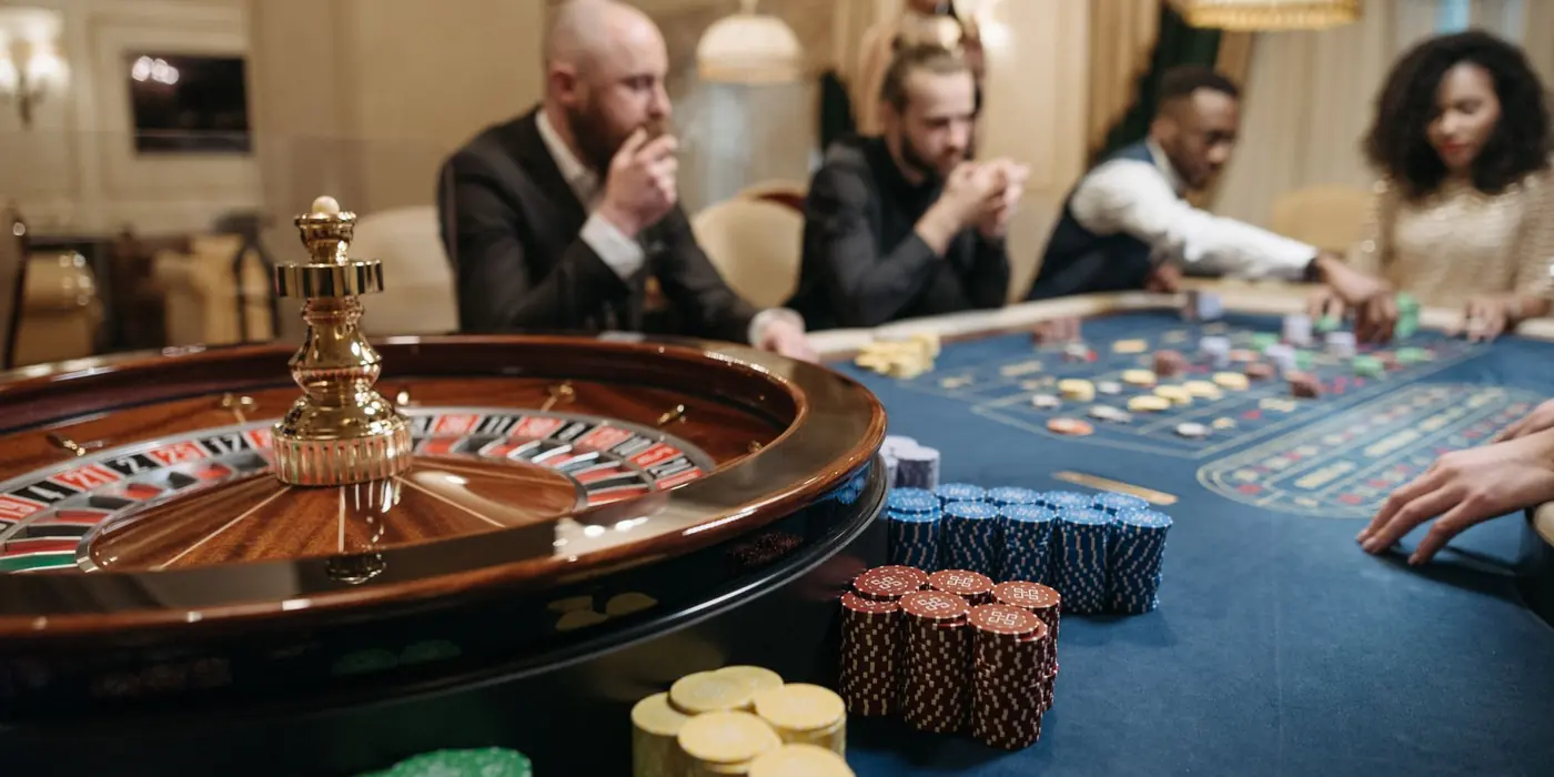 Giocatori attorno a un tavolo di roulette con fiches colorate